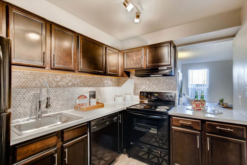 Kitchen with brown cabinets at Copperwood apartments in Westminster, CO